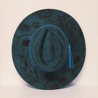 Green hat with floral patterns on a beige background