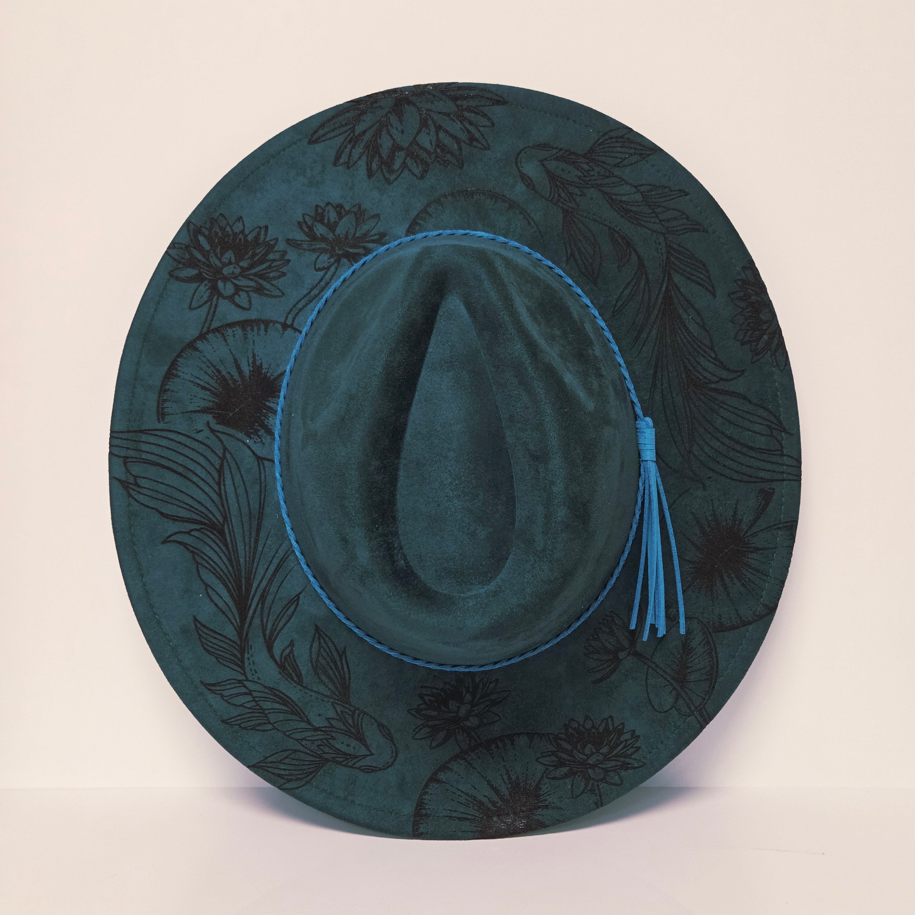 Green hat with floral patterns on a beige background