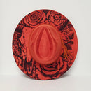 Red hat with black floral and abstract designs on a white background