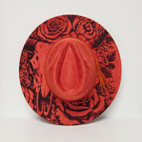 Red hat with black floral and abstract designs on a white background