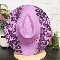Purple floral-patterned toilet seat cover on a toilet with a tiled bathroom background.