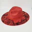 Red hat with black floral pattern on a white background