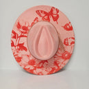 Pink hat with red floral and butterfly pattern on a light gray background