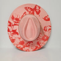Pink hat with red floral and butterfly pattern on a light gray background