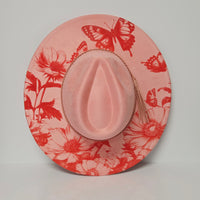 Pink hat with red floral and butterfly pattern on a light gray background