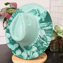 Green floral-patterned hat on a table with a white background