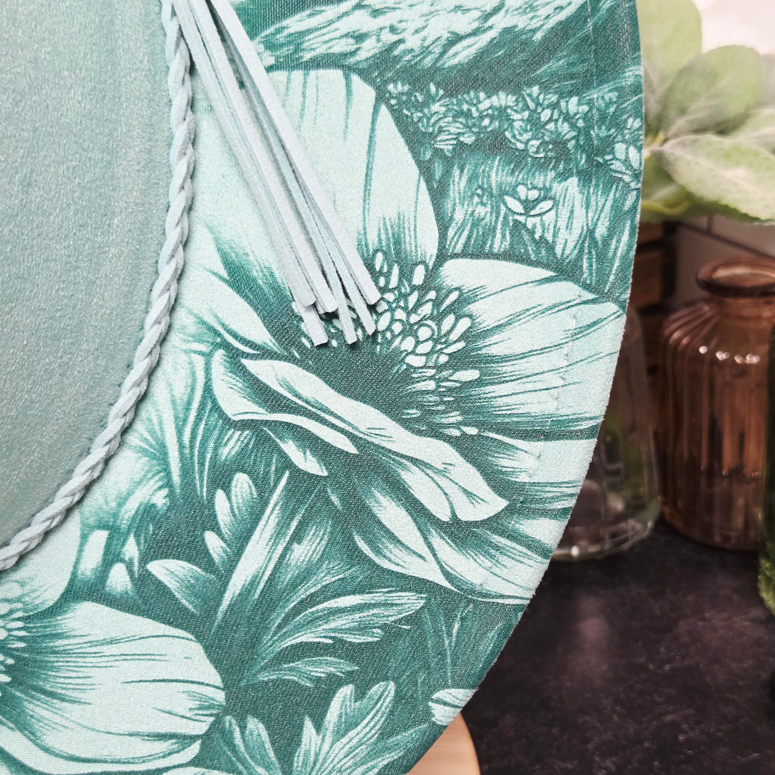 Close-up of a green floral-patterned fabric with a woven edge.