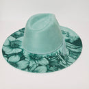 Teal floral-patterned wall hook on a light gray background