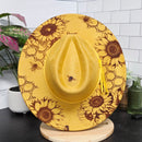 Yellow hat with sunflower and bee pattern on a white surface