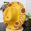 Yellow sunflower-patterned hat on a white surface with a blurred background