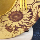 Close-up of a decorative item with sunflower patterns on a wooden surface.